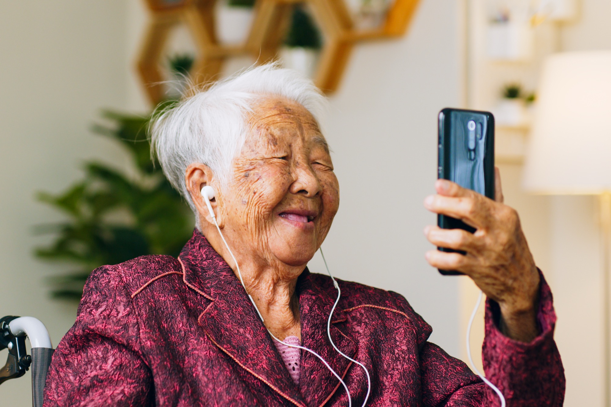 An older woman smiling while on a video call